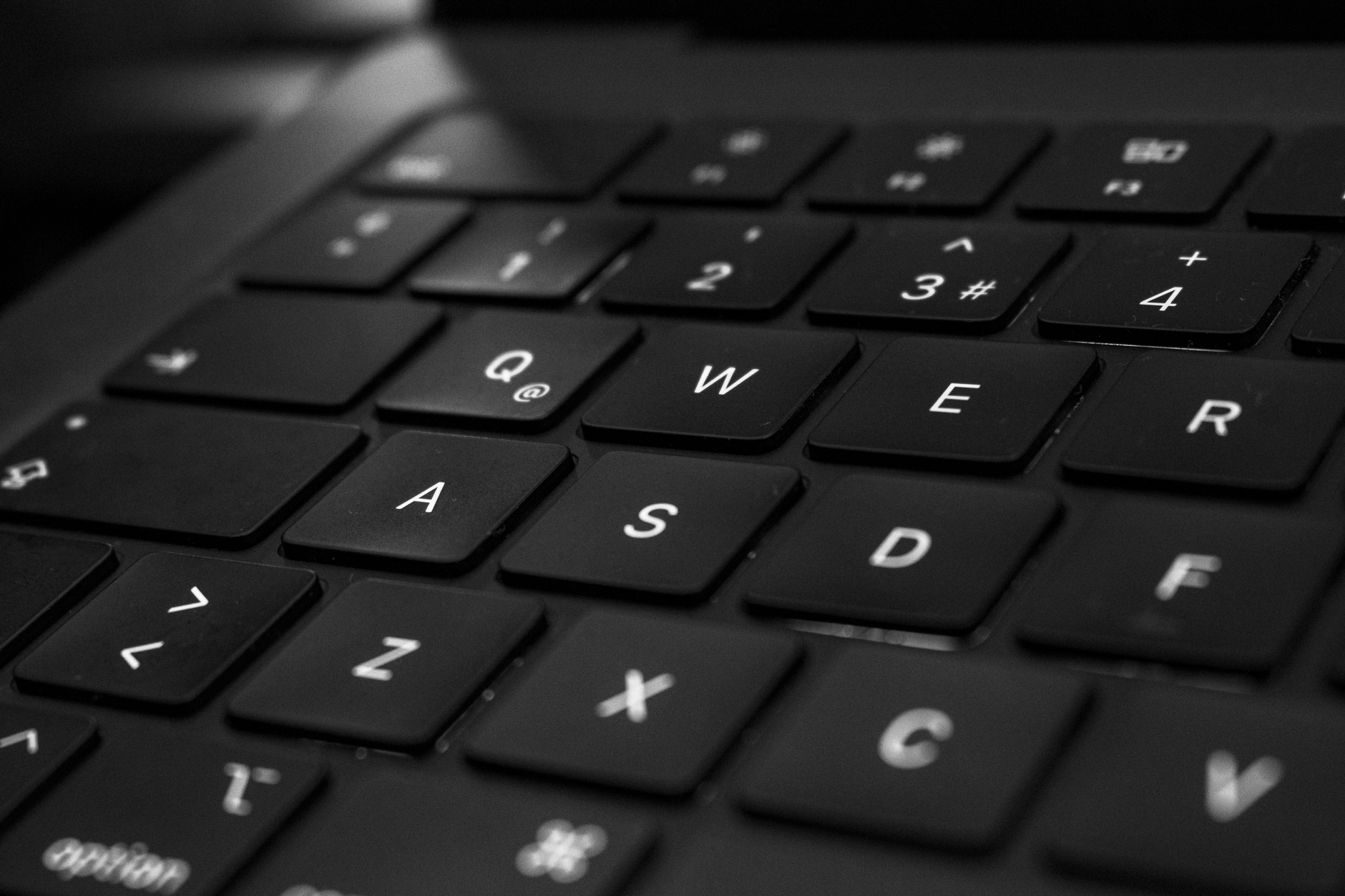 Svart-hvitt nærbilde av et tastatur med fokus på enkelte taster