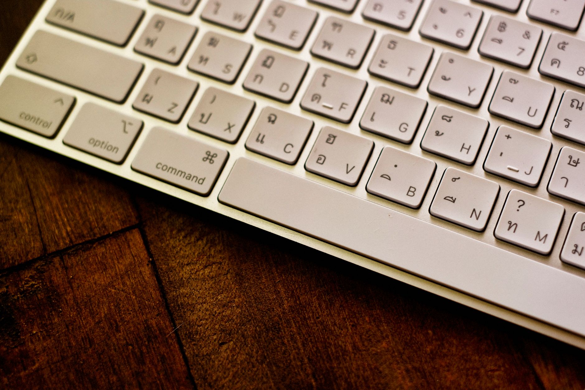 Nærbilde av et hvitt tastatur på en trepult, klar til produksjonsarbeid